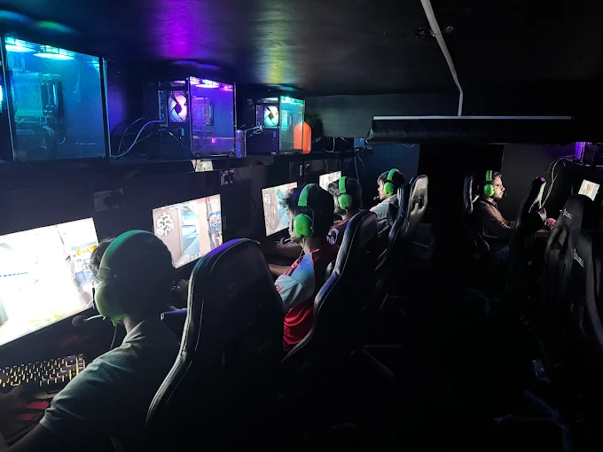 The neon floor at Nexus Gaming Cafe Ulwe - featuring 42 stations under a magenta-and-cyan light rig, hazed and tuned for focus.